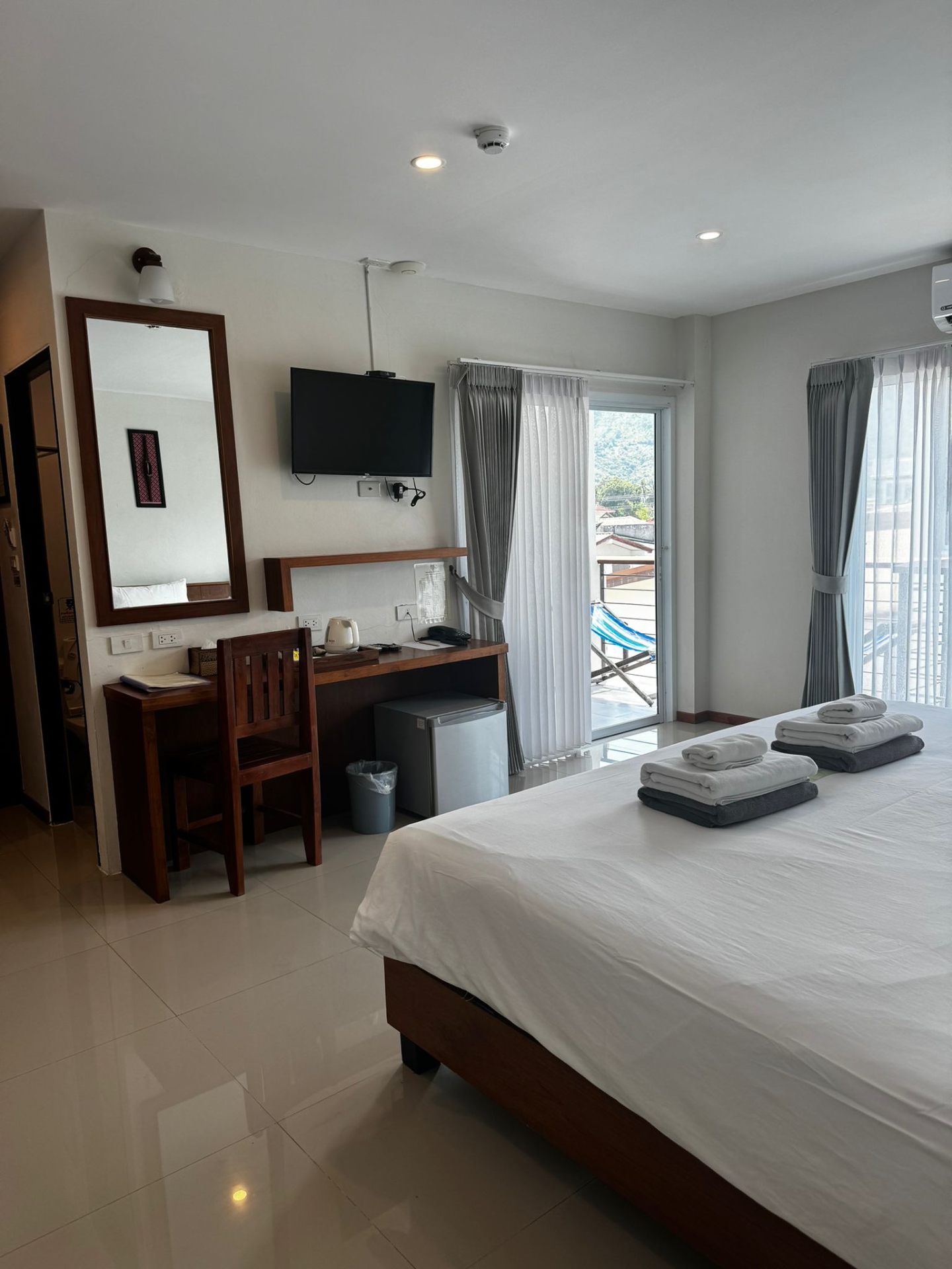 Bright hotel room with desk and balcony view