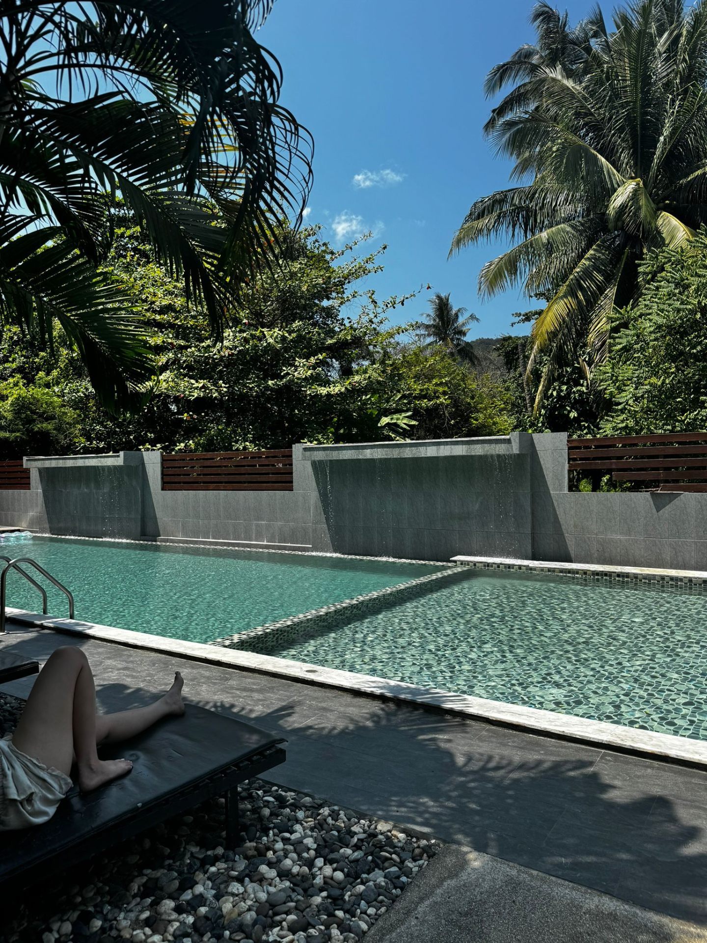 Hotel pool surrounded by tropical greenery